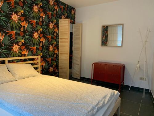 sypialnia z łóżkiem i kwiatową ścianą w obiekcie Elma’s Place w Gandawie