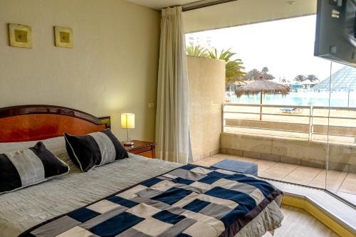 a bedroom with a bed with a view of the ocean at San Alfonso del Mar Algarrobo in Algarrobo