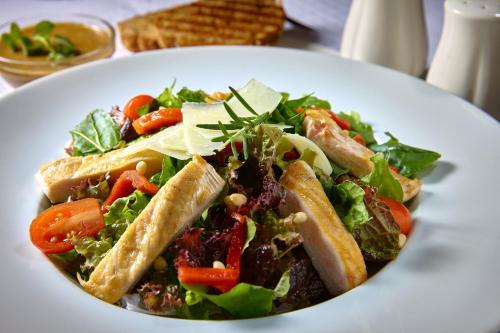 a plate of food with a salad on a table at Atrion Hotel in Heraklio