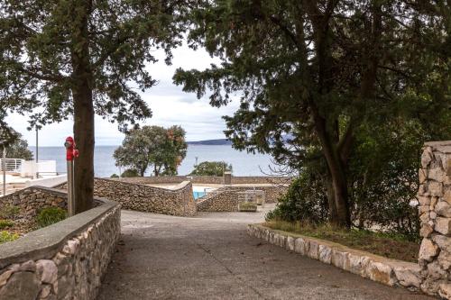 a stone path with trees and the ocean in the background at Marie in Krk