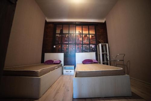 two beds in a room with a window at happy pandasN12 in Borjomi