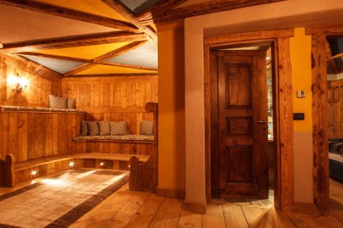 a room with wooden walls and wooden floors and a door at Au Coeur Des Neiges Resort SPA & FREE E-BIKE in Courmayeur