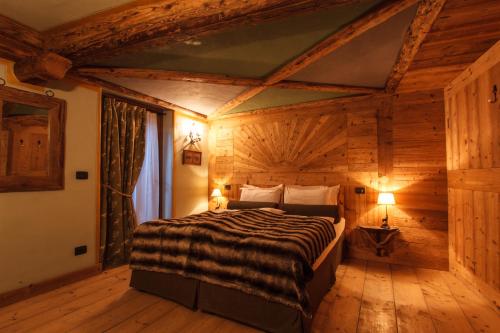 a bedroom with a bed in a wooden room at Au Coeur Des Neiges Resort SPA & FREE E-BIKE in Courmayeur