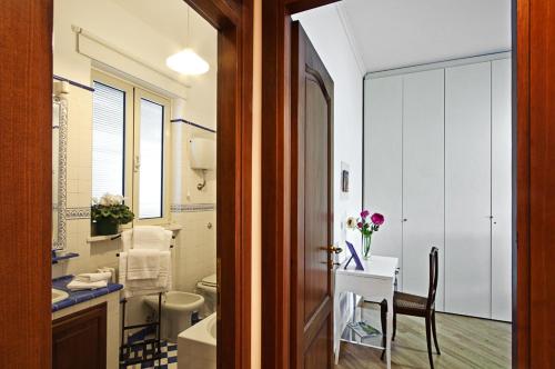 uma casa de banho com um lavatório, um WC e uma mesa em B&B SPLENDIDAE MUNDI em Roma