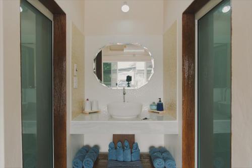 a bathroom with a sink and a mirror and blue shoes at Boutique Family Room Phitsanulok in Phitsanulok