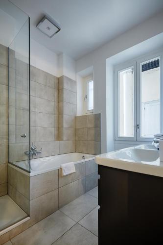 une grande salle de bain avec baignoire et douche dans l'établissement Veeve - Emerald Exuberance, à Paris