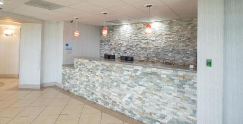 a lobby with a stone wall and a reception counter at Americas Best Value West Point in West Point