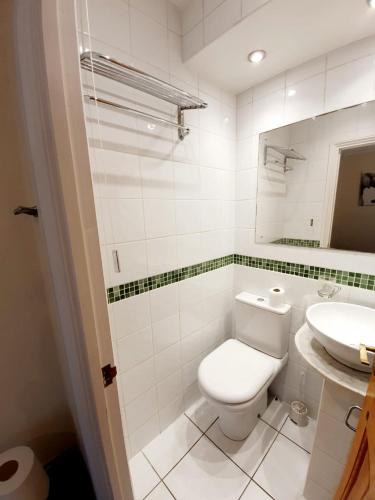 a white bathroom with a toilet and a sink at Chelmsford Centre House in Chelmsford