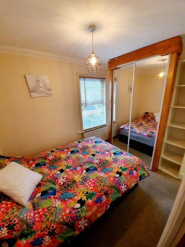ein Schlafzimmer mit einem Bett und einem großen Spiegel in der Unterkunft Chelmsford Centre House in Chelmsford