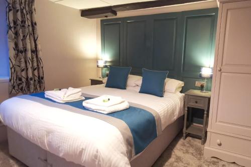 a bedroom with a large bed with towels on it at Furzeleigh Mill Inn in Buckfastleigh