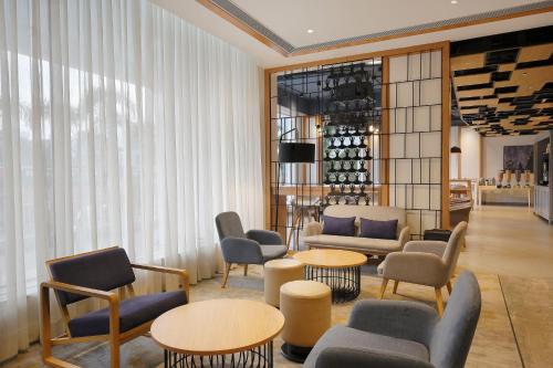 a lobby with chairs and tables and a wine cellar at Holiday Inn Express Chennai OMR Thoraipakkam by IHG in Chennai