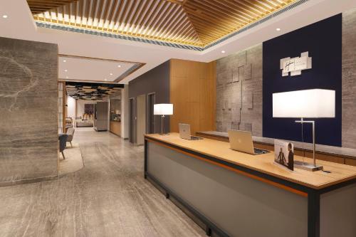 an office lobby with a reception desk with laptops on it at Holiday Inn Express Chennai OMR Thoraipakkam by IHG in Chennai