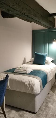 a bedroom with a large bed with a blue headboard at Furzeleigh Mill Inn in Buckfastleigh