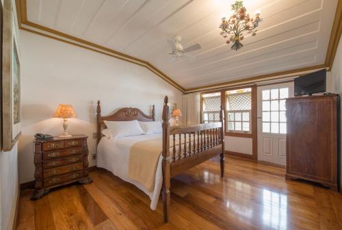 a bedroom with a bed and a dresser and a ceiling at Pousada do Douro in Ouro Preto