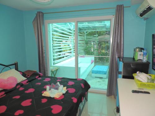 a bedroom with a bed and a window with a tub at Blue Paradise Residence in Rawai Beach