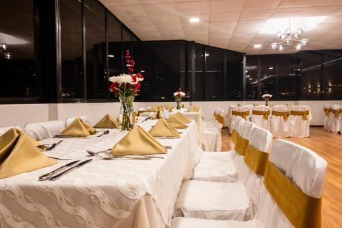 a banquet hall with white tables and gold napkins at Hotel Italia in Cuenca
