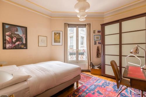 een slaapkamer met een bed en een bureau bij Veeve - Quai aux Fleurs Apartment in Parijs