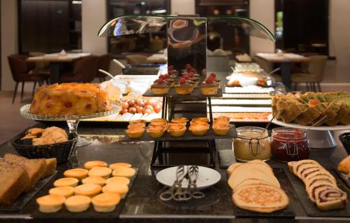 un buffet con molti tipi diversi di torte e pasticcini di TURIM Marquês Hotel a Lisbona