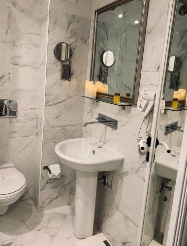 a white bathroom with a sink and a toilet at Atlantic Hotel - Free Parking in Sofia