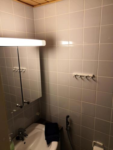a bathroom with a toilet and a light above it at Aaria Apartment in Tahkovuori