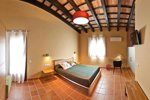 ein Schlafzimmer mit einem Bett in einem Zimmer in der Unterkunft Torre del Prior in Tortosa