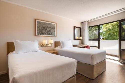 Habitación de hotel con 2 camas y ventana en Days Inn by Wyndham Montevideo, en Montevideo