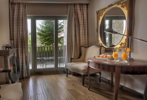 a living room with a table and a mirror at Aegli Arachova in Arachova