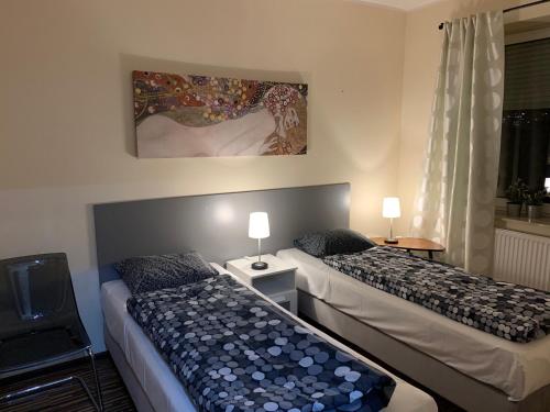 sypialnia z 2 łóżkami i obrazem na ścianie w obiekcie Apartament Podgórna 12 w Toruniu