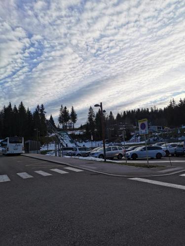 a parking lot with cars parked on the side of a road at Au Coeur des Rousses in Les Rousses