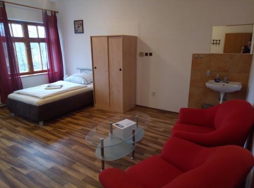 Město TouškovにあるPenzion u Náhonuのベッドルーム1室(ベッド1台、ソファ、テーブル付)