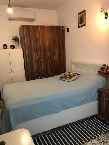 a bedroom with a bed and a wooden cabinet at Halikarnas Pansiyon in Bodrum City