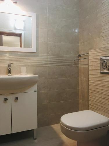 a bathroom with a toilet and a sink at Guest House Barbov in Obzor