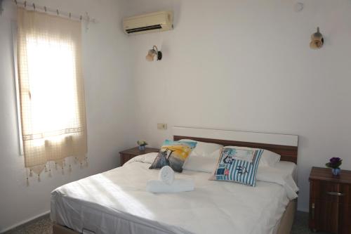 a bedroom with a white bed with a tray on it at Halikarnas Pansiyon in Bodrum City