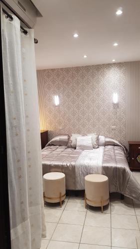 a bedroom with a large bed with two stools at Hotel Sangiuliano 132 centro storico Catania in Catania