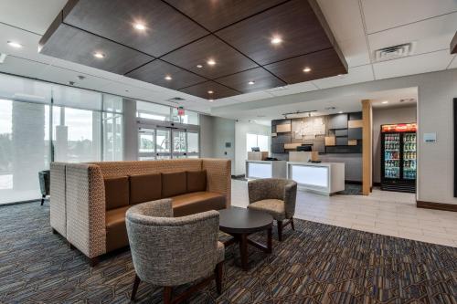 a lobby with a couch and chairs and a kitchen at Holiday Inn Express & Suites Dallas North - Addison by IHG in Addison