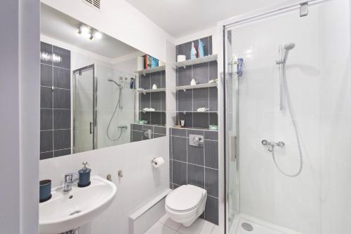 een badkamer met een douche, een toilet en een wastafel bij YOURAPART Zaspa in Gdańsk