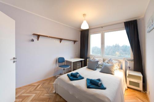 a bedroom with a bed with blue towels on it at YOURAPART Zaspa in Gdańsk