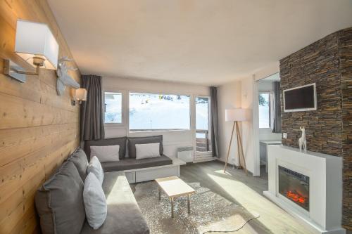 uma sala de estar com um sofá e uma lareira em SUPERBE T2 CLASSÉ, 34 M2, 3ÈME ÉTAGE, RÉSIDENCE « SÉPIA » AVORIAZ em Avoriaz