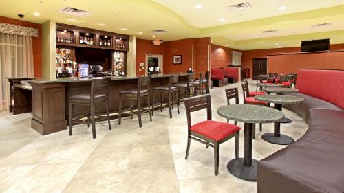 a bar in a restaurant with tables and chairs at Holiday Inn Garland by IHG in Garland