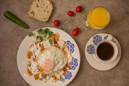 a table with a plate of food and a cup of coffee at Hotel Mamá Carlota in Querétaro