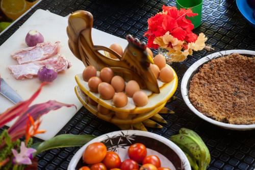 a table topped with bowls of eggs and other foods at La Kuka Hotel - Nuquí in Nuquí