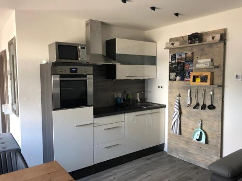 a kitchen with white cabinets and a microwave at Loft Ferienwohnung Allgäu in Memmingen