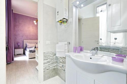 - une salle de bains blanche avec lavabo et une chambre dans l'établissement GEMMA DOMUS, à Rome