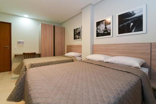 two beds in a hotel room with two beds at Star Hotel Limoeiro in Limoeiro