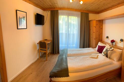 ein Hotelzimmer mit einem Bett und einem Fenster in der Unterkunft Gasthof Schöntal in Werfenweng