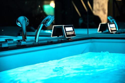 a bath tub with a sink with four taps at Seasons-Top of the city in Braşov