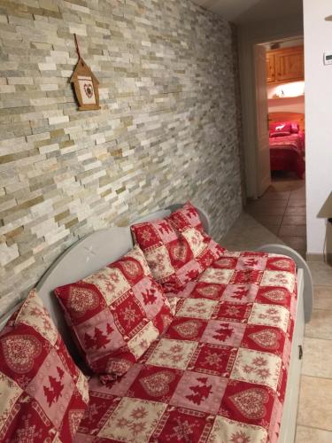 1 dormitorio con 1 cama con mantas rojas y blancas en L'étable, en Crévoux