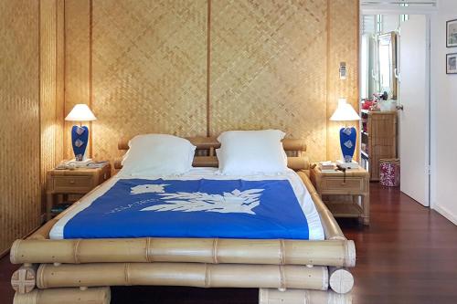 a bedroom with a bed with a blue and white blanket at Villa Iris in Pihaena