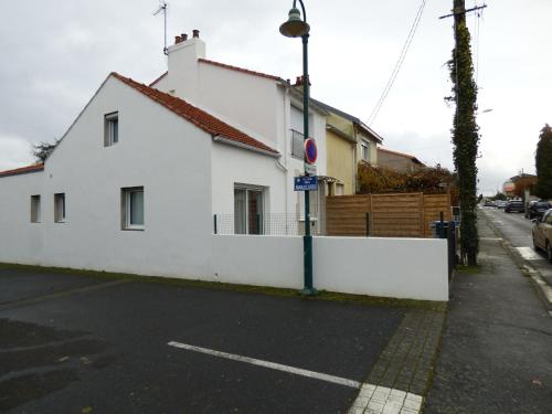 une maison blanche dans une rue avec une clôture dans l'établissement LA SUITE 22 BIS, à Saint-Sébastien-sur-Loire