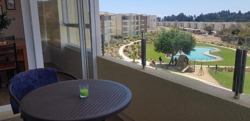 a table in a balcony with a view of a playground at Departamento Papudo in Papudo
